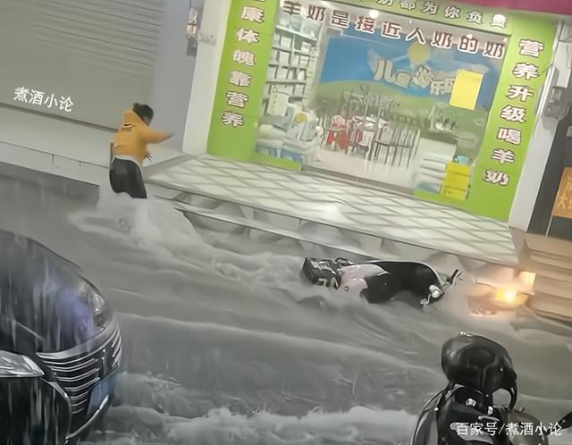 女骑手暴雨中送餐,摔倒后电动车被雨水冲走,网友感慨:生活不易